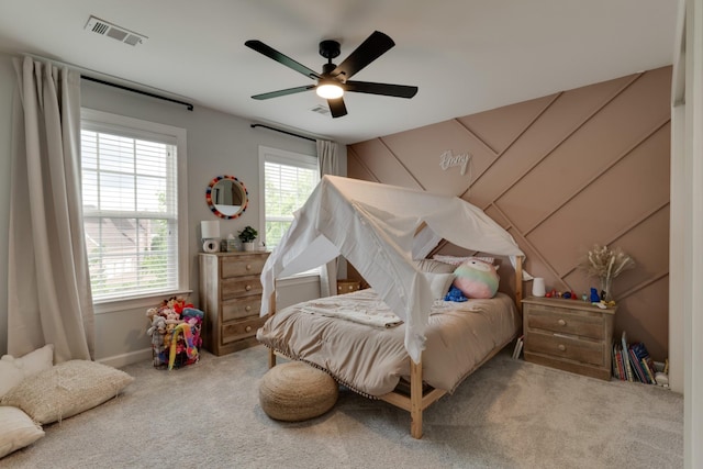 bedroom with ceiling fan, multiple windows, and carpet