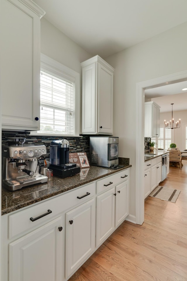 kitchen with white cabinetry, dishwasher, and tasteful backsplash