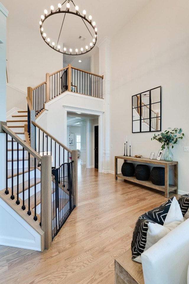 stairs featuring a notable chandelier, a high ceiling, and hardwood / wood-style flooring