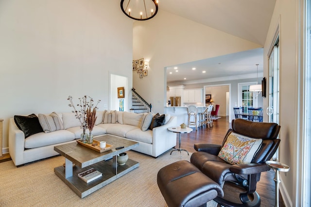 living room featuring a chandelier, light hardwood / wood-style flooring, and high vaulted ceiling