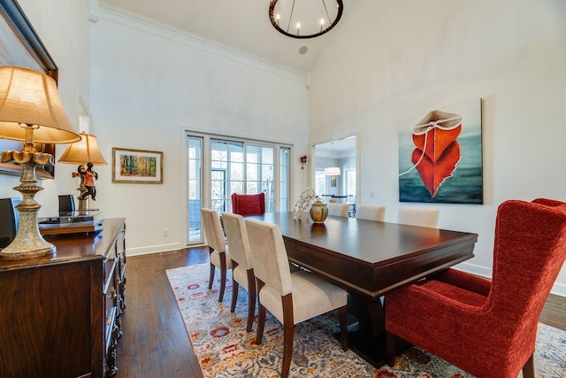 dining space with high vaulted ceiling, dark wood-type flooring, ornamental molding, and a chandelier