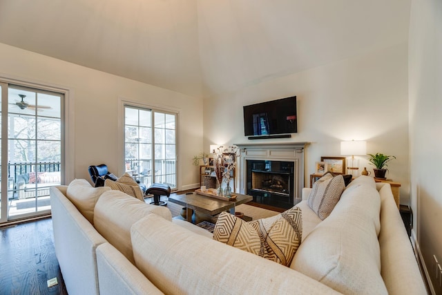 living room featuring ceiling fan, wood-type flooring, high vaulted ceiling, and a fireplace