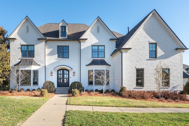 view of front facade with a front yard and french doors