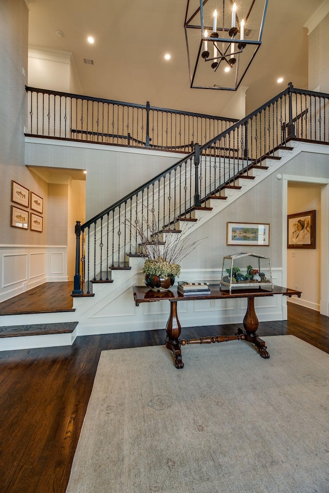 stairway featuring an inviting chandelier, crown molding, and hardwood / wood-style flooring