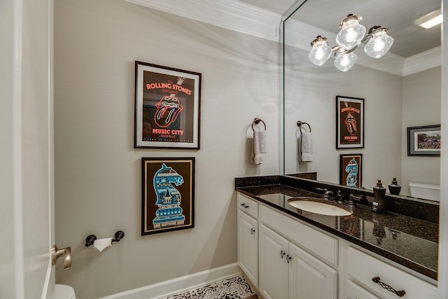 bathroom featuring toilet, vanity, and ornamental molding