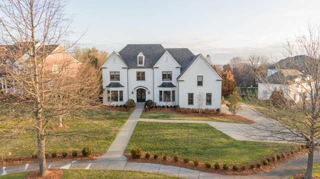 french country home featuring a front yard