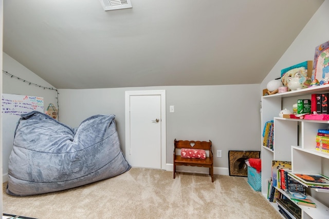 sitting room featuring carpet floors and vaulted ceiling