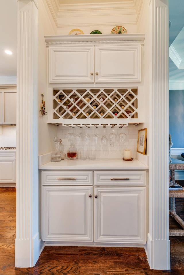 bar featuring dark hardwood / wood-style floors, ornamental molding, and tasteful backsplash