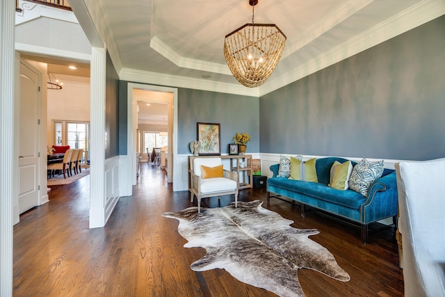 interior space featuring a tray ceiling, dark hardwood / wood-style flooring, crown molding, and a chandelier