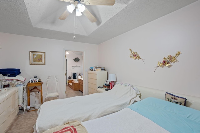 carpeted bedroom with ceiling fan, a textured ceiling, and a tray ceiling