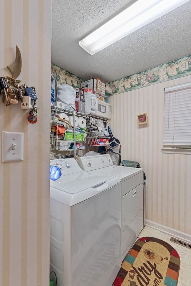 clothes washing area featuring a textured ceiling and independent washer and dryer