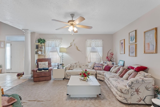 tiled living room featuring a textured ceiling, ceiling fan, a wealth of natural light, and decorative columns