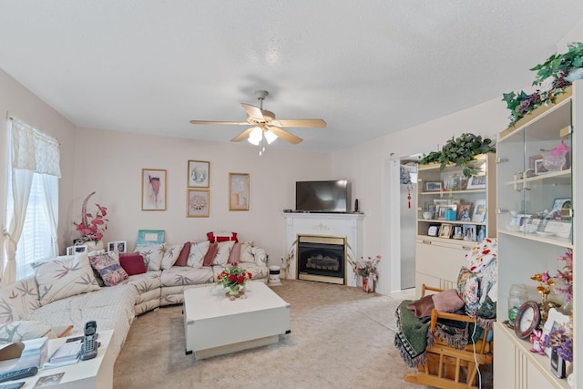 living room featuring ceiling fan, light colored carpet, and a textured ceiling