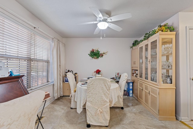 dining space featuring ceiling fan and a textured ceiling