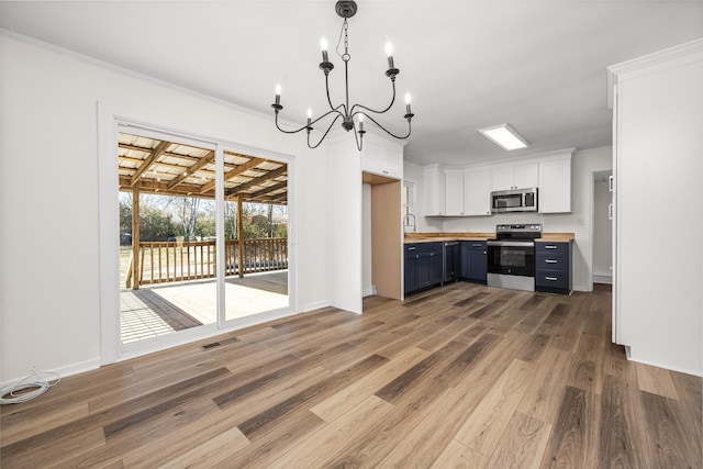 kitchen featuring wood counters, white cabinetry, stainless steel appliances, hanging light fixtures, and dark hardwood / wood-style floors