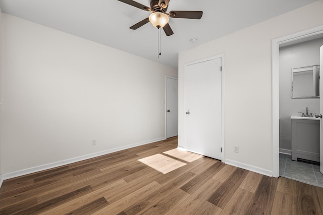 unfurnished bedroom with ceiling fan, wood-type flooring, and ensuite bathroom