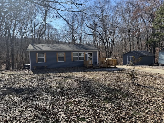 ranch-style house with a deck and a storage shed