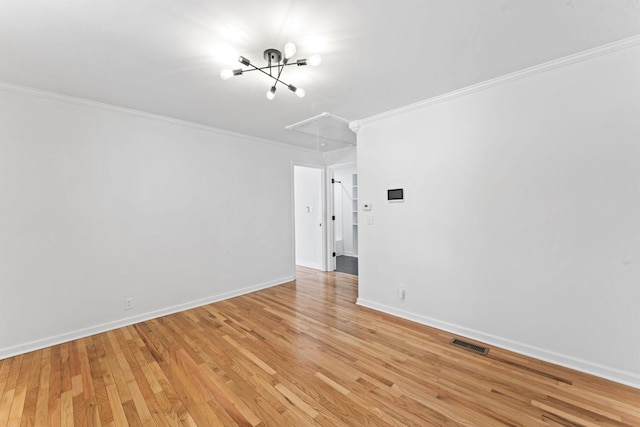 spare room featuring ornamental molding and light hardwood / wood-style floors