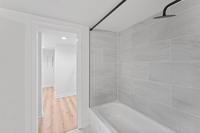 full bath with shower / bathtub combination, wood finished floors, and baseboards