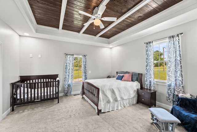 bedroom featuring light carpet, a raised ceiling, ornamental molding, ceiling fan, and wooden ceiling