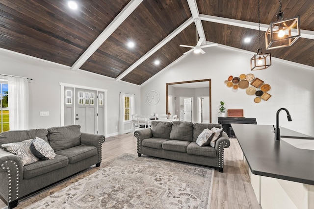 living room featuring ceiling fan, light hardwood / wood-style floors, sink, wood ceiling, and high vaulted ceiling