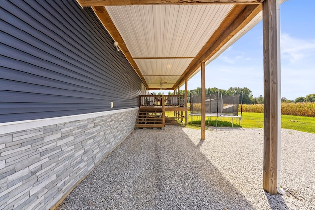 view of patio / terrace featuring a wooden deck and a trampoline