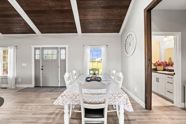 dining space with light hardwood / wood-style floors, wooden ceiling, sink, and vaulted ceiling