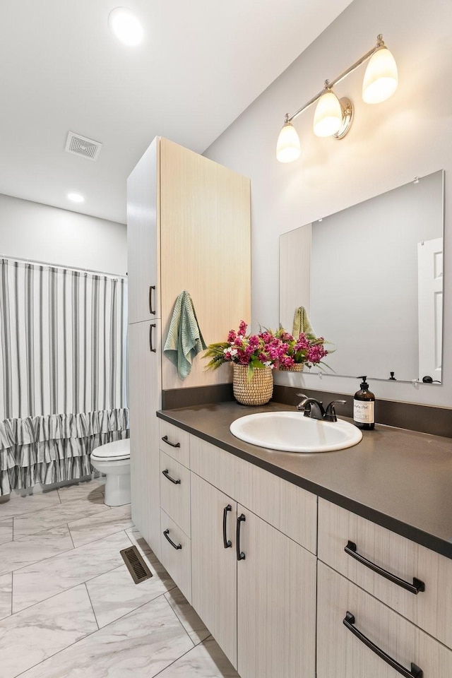 bathroom featuring toilet and vanity