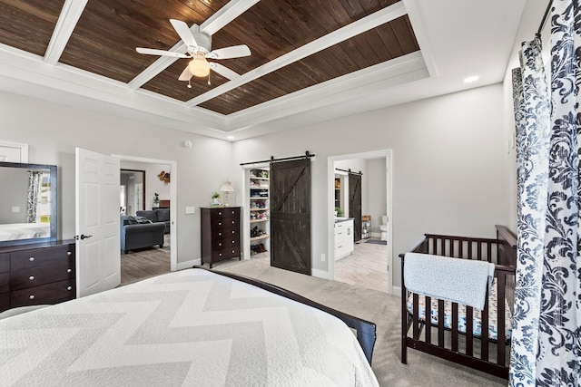 bedroom featuring wood ceiling, ceiling fan, connected bathroom, and a barn door