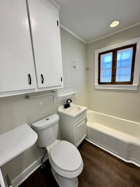 full bathroom featuring toilet, vanity, shower / bathing tub combination, hardwood / wood-style flooring, and ornamental molding