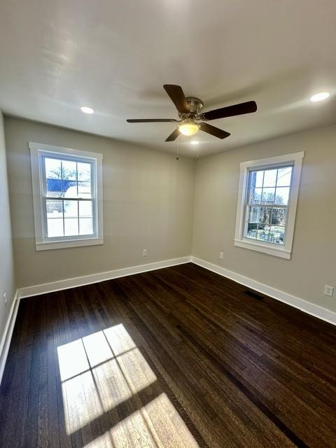 spare room featuring ceiling fan and dark wood-type flooring