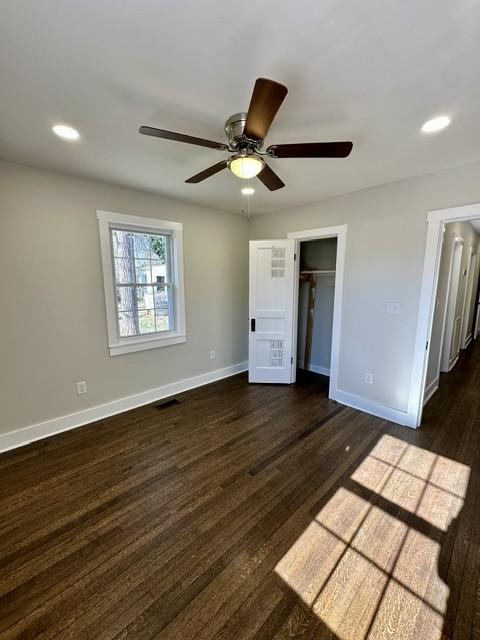 unfurnished bedroom with ceiling fan, dark hardwood / wood-style floors, and a closet