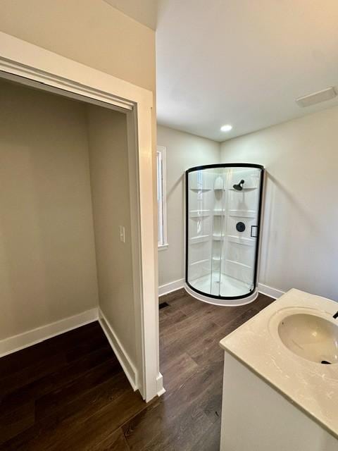 bathroom featuring a shower with shower door, vanity, and hardwood / wood-style floors