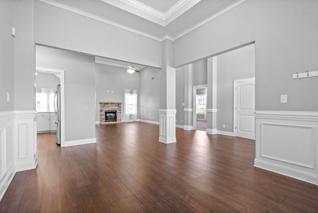 unfurnished living room featuring ceiling fan, a healthy amount of sunlight, and ornamental molding