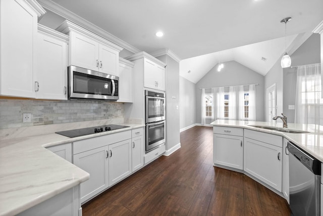 kitchen featuring appliances with stainless steel finishes, white cabinetry, tasteful backsplash, sink, and hanging light fixtures