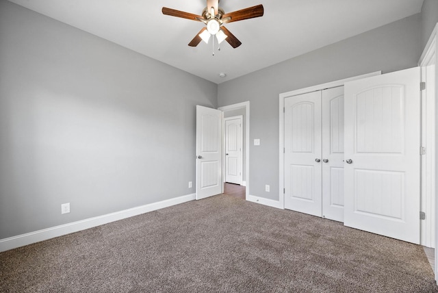 unfurnished bedroom with ceiling fan, a closet, and dark colored carpet