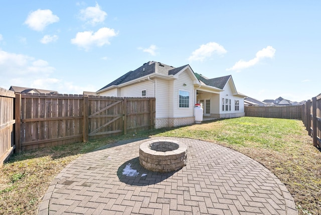 back of house with a patio area, an outdoor fire pit, and a yard