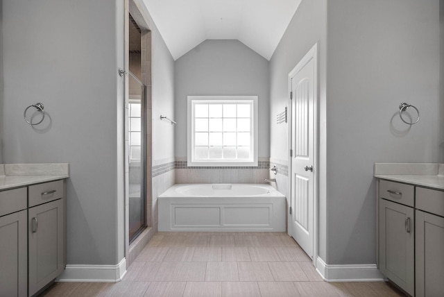 bathroom with vaulted ceiling, plus walk in shower, and vanity