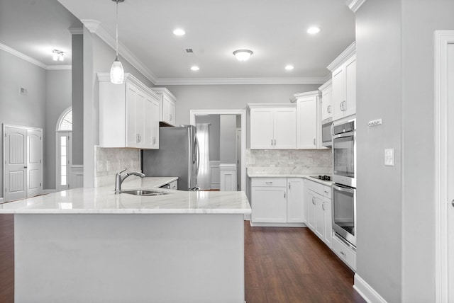 kitchen featuring kitchen peninsula, sink, appliances with stainless steel finishes, ornamental molding, and white cabinets