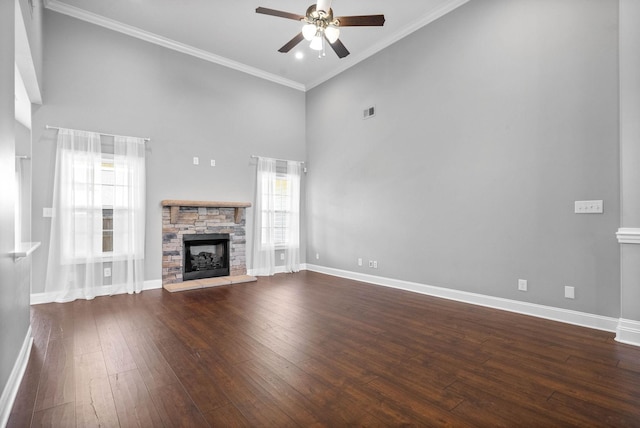 unfurnished living room featuring a fireplace, ceiling fan, plenty of natural light, and dark wood-type flooring