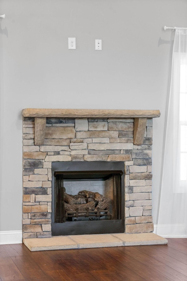 details featuring hardwood / wood-style flooring and a stone fireplace