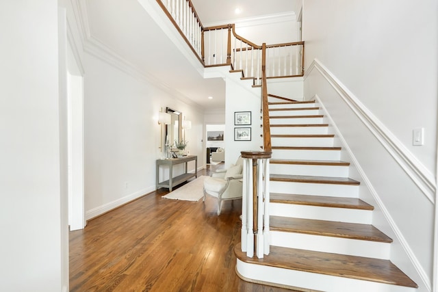 stairway with crown molding, a fireplace, and wood-type flooring