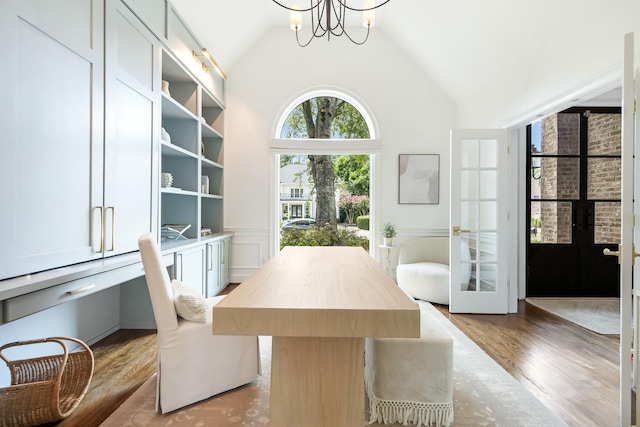 dining room with lofted ceiling, french doors, a notable chandelier, and light hardwood / wood-style flooring