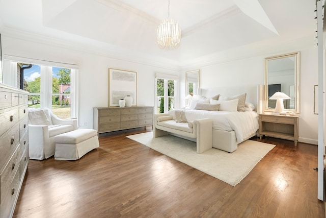 bedroom with an inviting chandelier, dark hardwood / wood-style flooring, and a tray ceiling