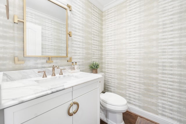 bathroom featuring toilet, crown molding, hardwood / wood-style flooring, and vanity