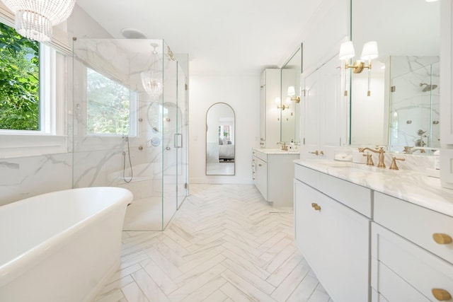 bathroom with vanity, independent shower and bath, and a chandelier