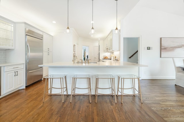 kitchen featuring built in refrigerator, pendant lighting, and white cabinets