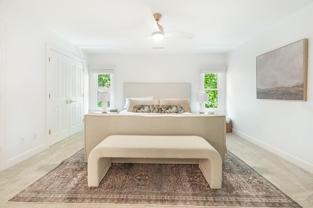 carpeted bedroom featuring ceiling fan and a closet