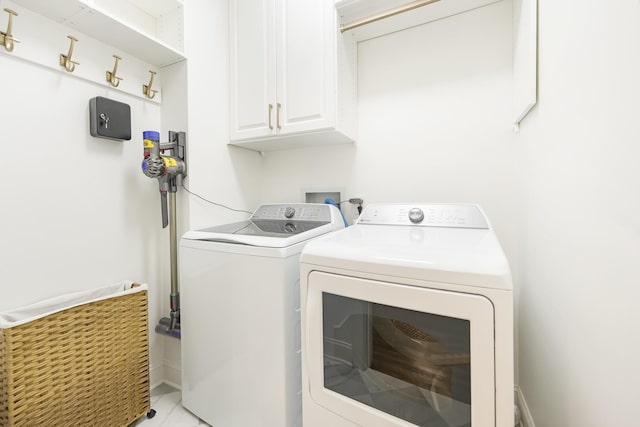 laundry room featuring cabinets and washing machine and clothes dryer