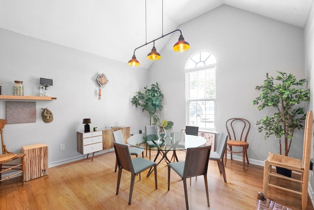 dining room with light hardwood / wood-style flooring and lofted ceiling